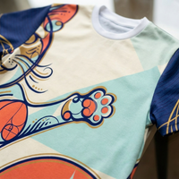 Navy blue t-shirt with a Sacred Geometry-inspired Spiral Cat Smile design; lifestyle studio shot showing the graphic in bold lines and warm accent colors #FF6B6B, #FFD166, #DFF3E3, on a textured fabric, close-up and full view